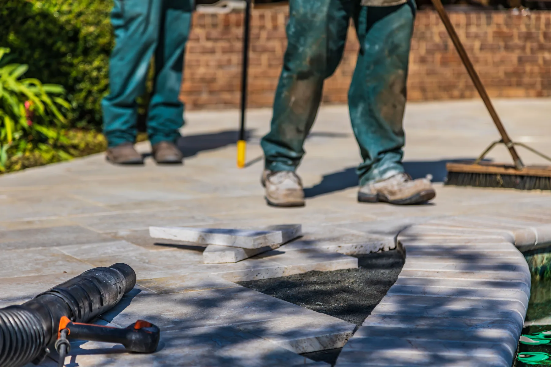 Landscapers carefully installing a paved patio